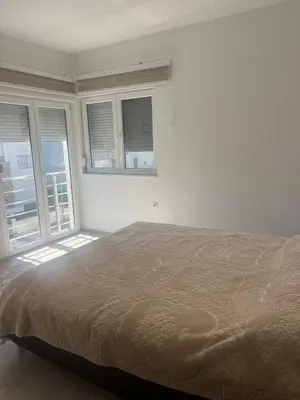 a bedroom with a large bed in a room with windows at Vila Dior Donji Stoj in Donji Štoj