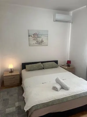 a bedroom with a bed and a picture on the wall at Lamour Apartment in Ulcinj