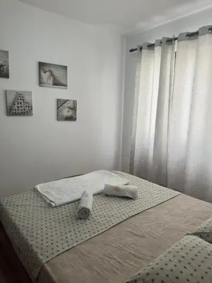 a bed with towels on it in a bedroom at Lamour Apartment in Ulcinj
