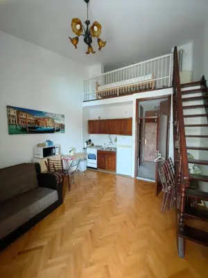 a living room with a couch and a table and a kitchen at Small duplex near beach in Sutomore