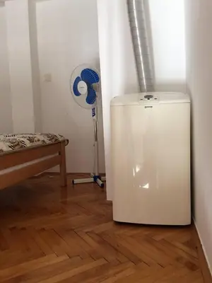 a white refrigerator in a room next to a bed at Small duplex near beach in Sutomore