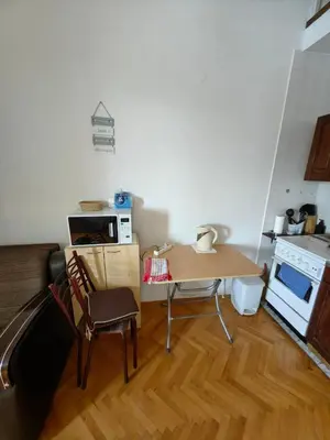 a small kitchen with a table and chairs in a room at Small duplex near beach in Sutomore