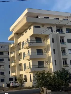 a large white building with a car parked in front of it at Ulcinj La Miga2 in Ulcinj