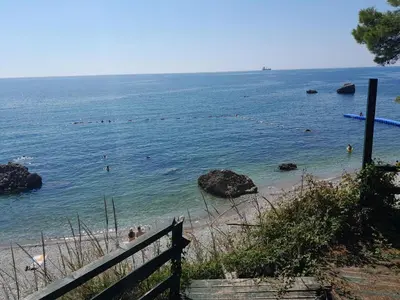 a beach with people swimming in the water at Trosoban stan in Bar