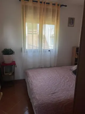a bedroom with a bed and a window and a plant at Trosoban stan in Bar