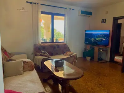 a living room with a couch and a table and a tv at Trosoban stan in Bar