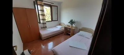a small room with two beds and a window at Trosoban stan in Bar