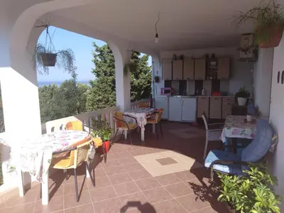 a patio with a table and chairs and a kitchen at Trosoban stan in Bar