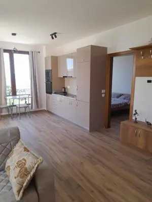 a living room with a couch and a kitchen at Apart SASHENKA 2 in Dobra Voda