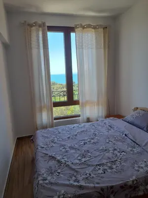 a bedroom with a bed and a large window at Apart SASHENKA 2 in Dobra Voda