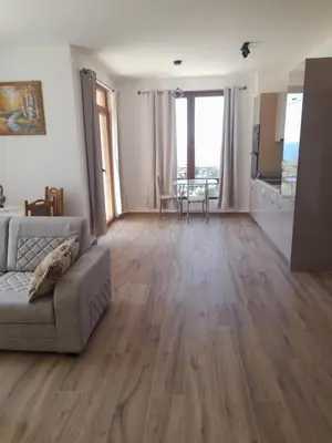 a living room with a couch and a kitchen at Apart SASHENKA 2 in Dobra Voda