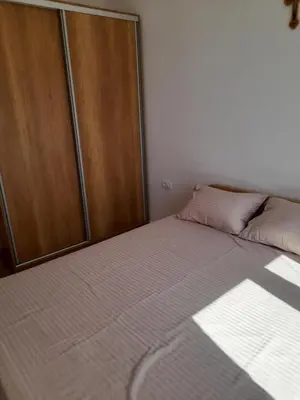 a bedroom with a bed and a wooden cabinet at Apart SASHENKA 2 in Dobra Voda