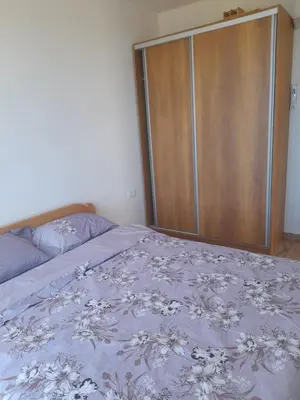 a bedroom with a bed and a wooden closet at Apart SASHENKA 2 in Dobra Voda