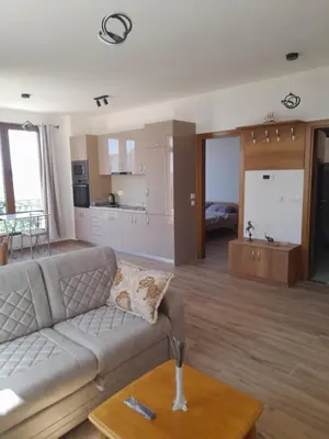 a living room with a couch and a kitchen at Apart SASHENKA 2 in Dobra Voda