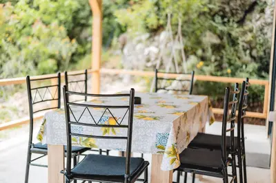 a table with four chairs and a tablecloth on it at Olive Hills holiday homes 3 in Dobra Voda