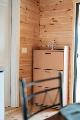 a dining room with wooden walls and a table and chairs at Olive Hills holiday homes 3 in Dobra Voda