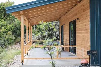 a wooden house with a blue roof at Olive Hills holiday homes 3 in Dobra Voda