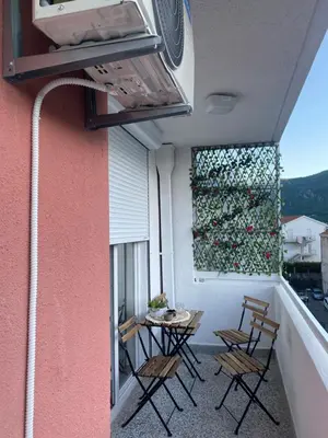 a balcony with chairs and a table and a window at Boka View Martiva in Kotor