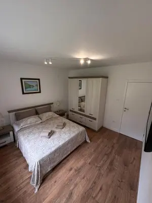 a bedroom with a large bed and wooden floors at Boka View Martiva in Kotor