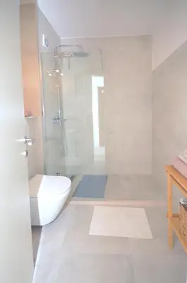 a white bathroom with a shower and a toilet at Zlatna Boska in Kotor