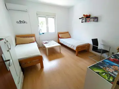 a small room with two beds and a table at Zlatna Boska in Kotor