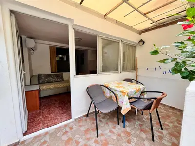 a table and chairs on the balcony of a house at Apartments Gvozdenović in Petrovac na Moru