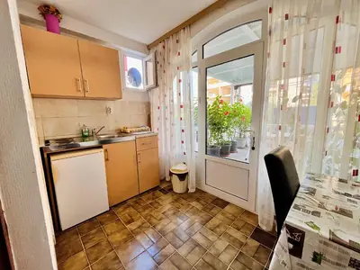 a kitchen with a table and a door with a window at Apartments Gvozdenović in Petrovac na Moru