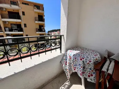 a table and chair on a balcony with a view at Apartments Gvozdenović in Petrovac na Moru