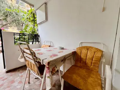 a table and chairs in a room with a balcony at Apartments Gvozdenović in Petrovac na Moru