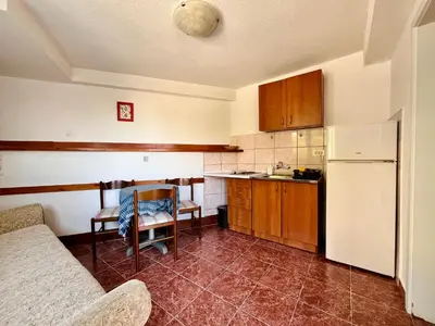 a kitchen with a white refrigerator and a table at Apartments Gvozdenović in Petrovac na Moru