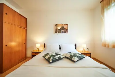 a bedroom with a large white bed with two pillows at Family Apartments Mont Budva in Budva