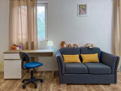 a blue couch with yellow pillows next to a desk at Ceres Apartments in Utjeha