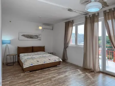 a bedroom with a bed and a large window at Ceres Apartments in Utjeha
