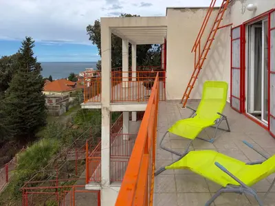 a balcony with two chairs and an orange ladder at Ceres Apartments in Utjeha