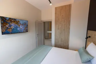 a bedroom with a bed and a painting on the wall at Apartments Piano in Utjeha