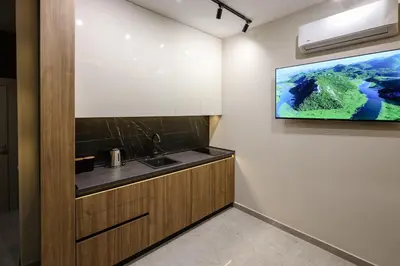 a kitchen with a sink and a tv on the wall at Apartments Piano in Utjeha