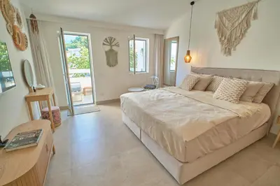 a bedroom with a large bed in a room with a table at Mind Wellness Montenegro in Sveti Stefan