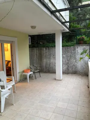 an outdoor patio with chairs and a glass roof at Mia apartments in Petrovac near the sea in Petrovac na Moru
