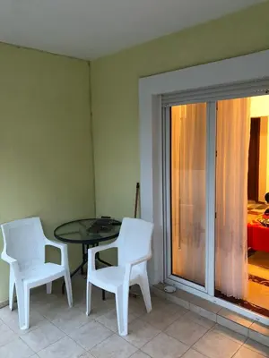 a dining room with a table and two white chairs at Mia apartments in Petrovac near the sea in Petrovac na Moru
