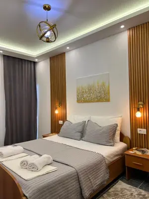a bedroom with a large bed with towels on it at Golden Sun Apartments in Ulcinj