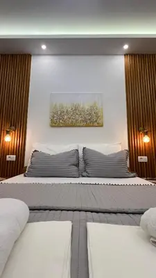 a bedroom with two beds and a painting on the wall at Golden Sun Apartments in Ulcinj