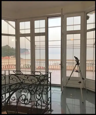 a room with a camera on a tripod in front of windows at Villa VIktoria in Petrovac na Moru