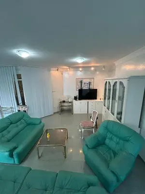 a living room with two green couches and a table at Villa VIktoria in Petrovac na Moru