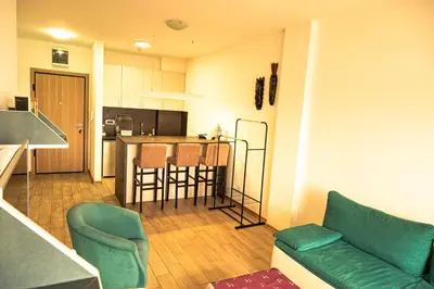 a living room with a couch and a kitchen at Modern City Flat Budva - Balcony & Garage Included in Budva