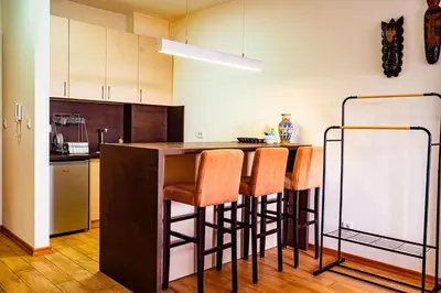 a kitchen with a bar with stools and a counter at Modern City Flat Budva - Balcony & Garage Included in Budva