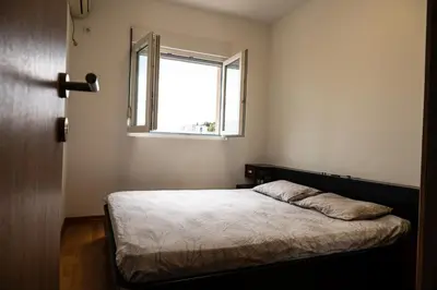 a bedroom with a bed and a window at Modern City Flat Budva - Balcony & Garage Included in Budva