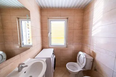 a bathroom with a sink and a toilet and window at Apartment Sambra in Budva