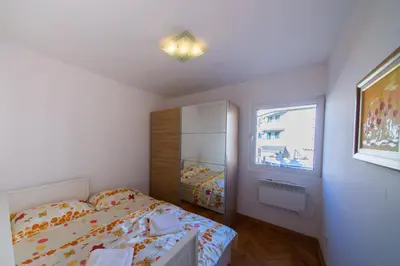 a small bedroom with a bed and a window at Apartment Sambra in Budva