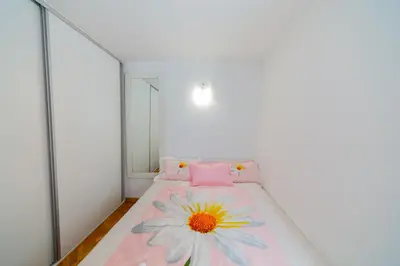 a bedroom with a pink bed with a flower on it at Apartment Sambra in Budva