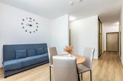 a living room with a blue couch and a table and chairs at Lipovina Anres Apartment in Petrovac na Moru